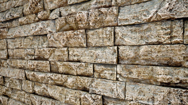 A close up view of textured stone wall showing detailed natural stone layers