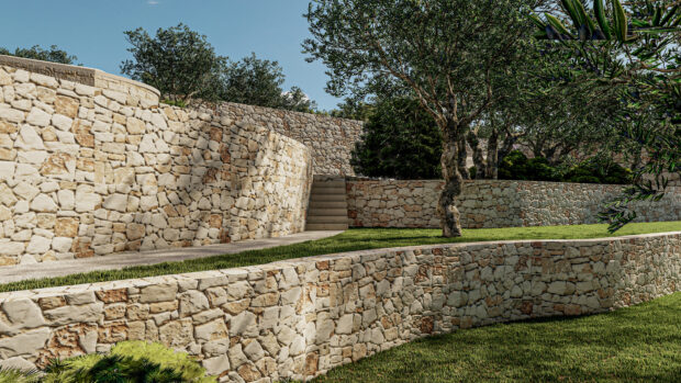 Curved stone wall with green grass and trees in a sunny outdoor landscape