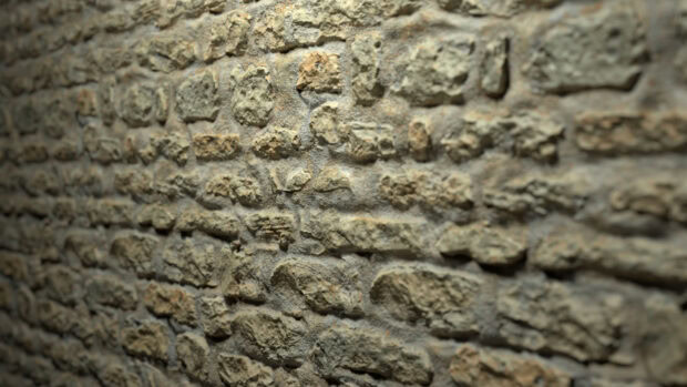 Close up view of a textured stone wall with rough and uneven stones in natural colors