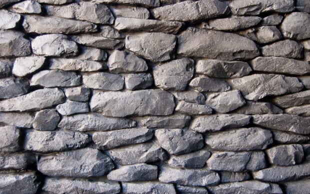 Rough stone wall with textured surface showing natural stone arrangement