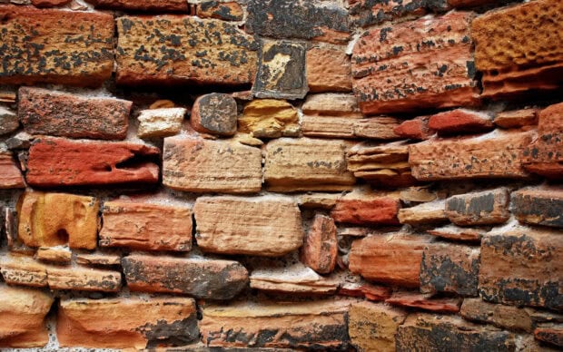 Close up of the natural stone wall with various colors and rough textures