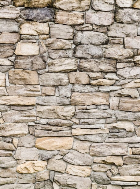 A close up view of natural stone wall with various shapes and colors in high definition