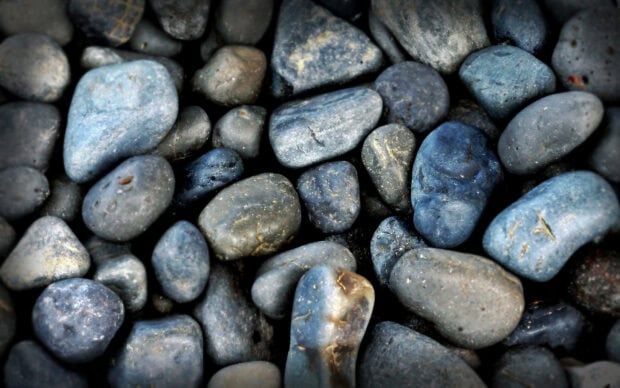 Close up of natural stone rocks with various shades of blue and gray scattered together