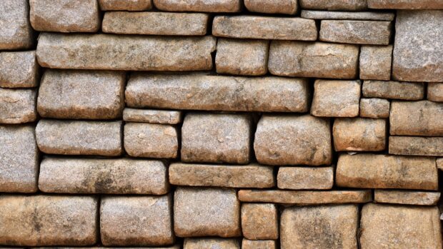 Close up texture of natural stone wall with various shapes and sizes of stone blocks