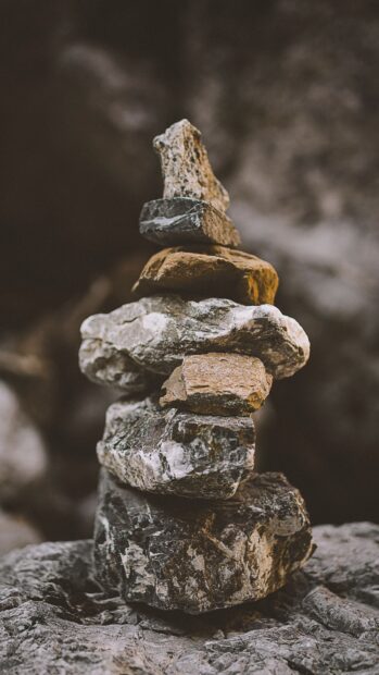 A balanced stack of natural stone forming a tall tower in a rocky outdoor setting