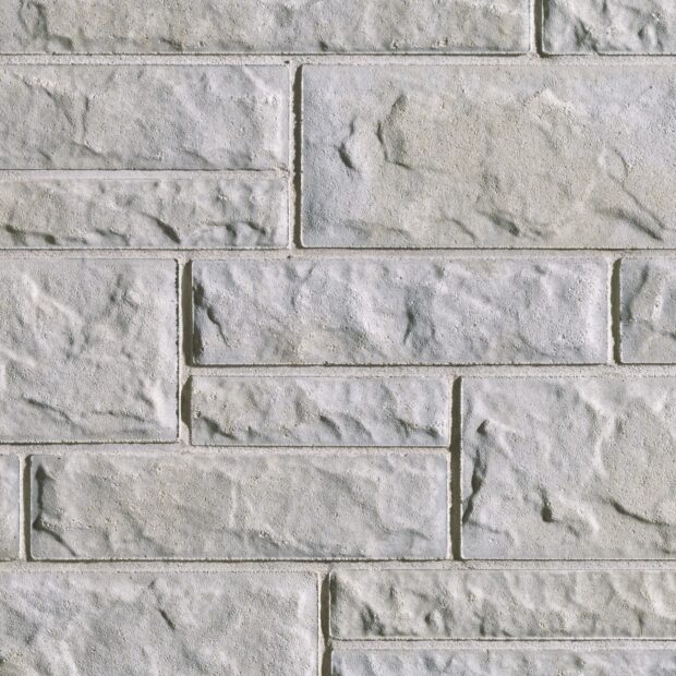 Rough textured stone bricks forming a gray solid wall surface