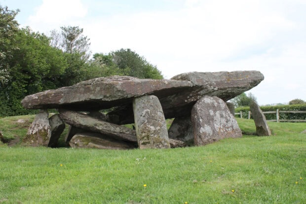 Ancient stone formation with large natural stones standing on grassy field
