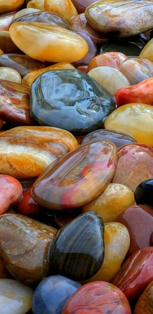 Smooth polished stone surface with various colors and textures reflecting light naturally