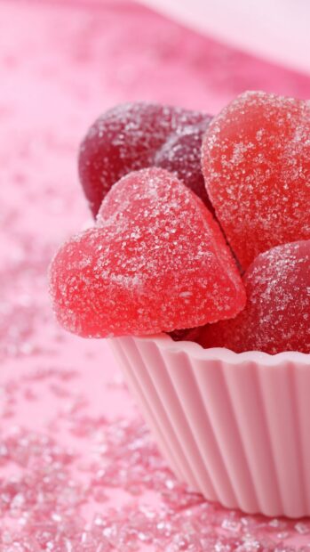 Heart shaped sugar candies coated with granulated sugar in a pink cup
