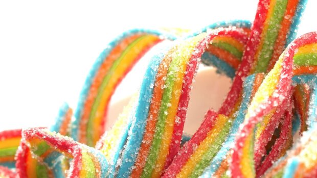 Colorful sugar stripes with granulated sugar crystals close up view