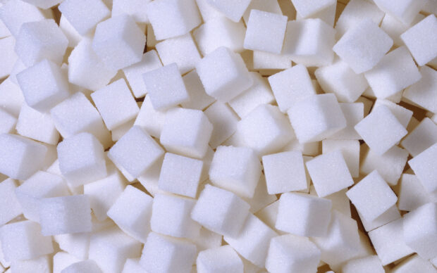 A close up view of white sugar cubes stacked randomly together