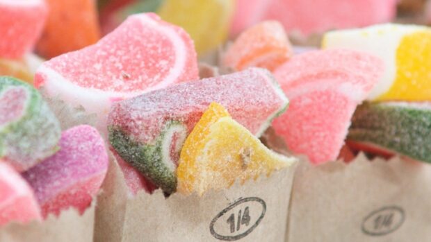 Colorful sugar candies coated with sugar crystals in paper bags