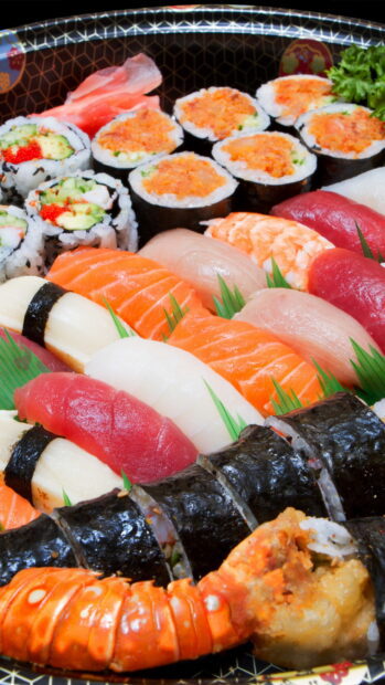 Assorted sushi rolls and nigiri with fresh fish and seafood on a traditional tray