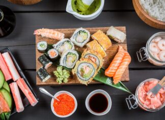 A delicious assortment of sushi with shrimp cucumber and salmon rolls on a wooden board