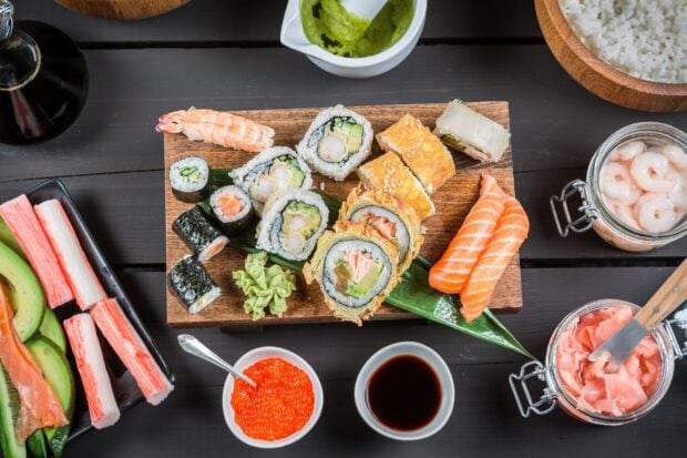 A delicious assortment of sushi with shrimp cucumber and salmon rolls on a wooden board
