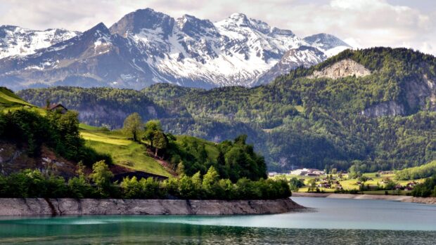 Snow capped mountains and green hills in Switzerland landscape scenery