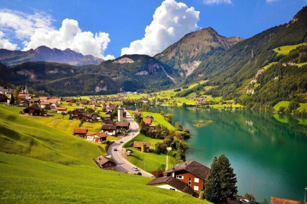 Scenic Switzerland village landscape with lake and mountains under blue sky