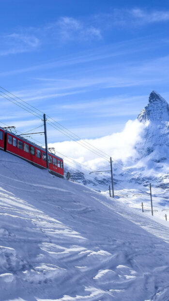 Scenic Switzerland mountain with a red train traveling through snowy landscape