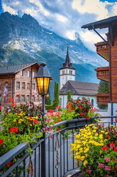 Traditional Switzerland village with flowers and mountains in the background