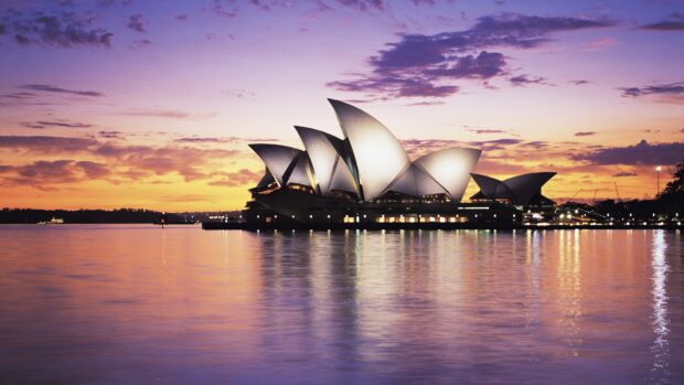 Sydney iconic architecture at sunset with calm water reflections