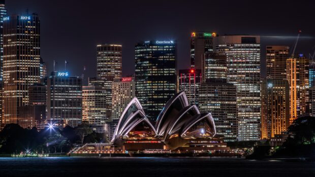 Night view of Sydney cityscape with iconic Opera House and illuminated skyscrapers