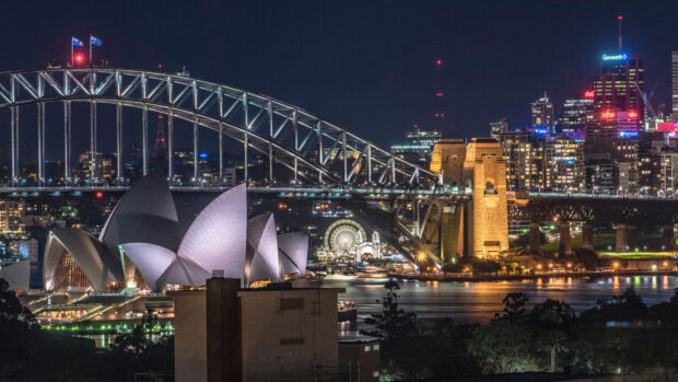 Night view of Sydney Harbour Bridge and iconic Sydney Opera House illuminated at night