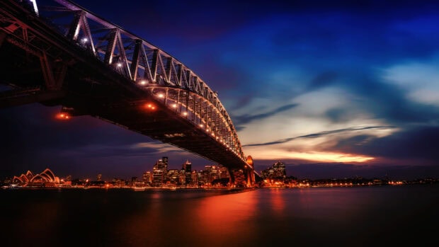 Sydney Harbour Bridge illuminated at dusk over the city skyline
