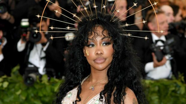 Sza wearing a unique star shaped headpiece and intricate makeup at a public event