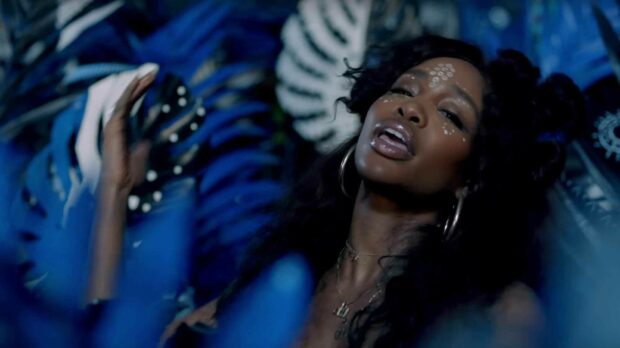 Sza with face paint surrounded by blue artistic patterns in high definition