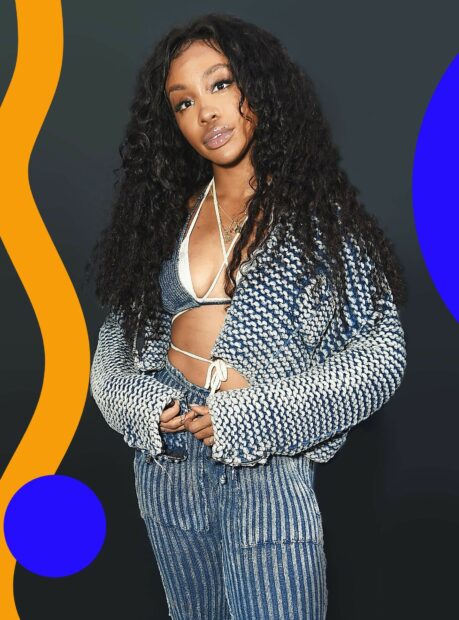 Young woman with curly hair wearing a knit cardigan and denim pants in stylish outfit