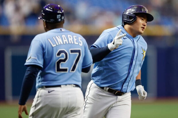 Tampa Bay Rays player celebrating with teammate in blue uniform during baseball game