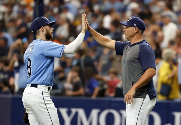 Tampa Bay Rays player and coach celebrating with a high five during a baseball game