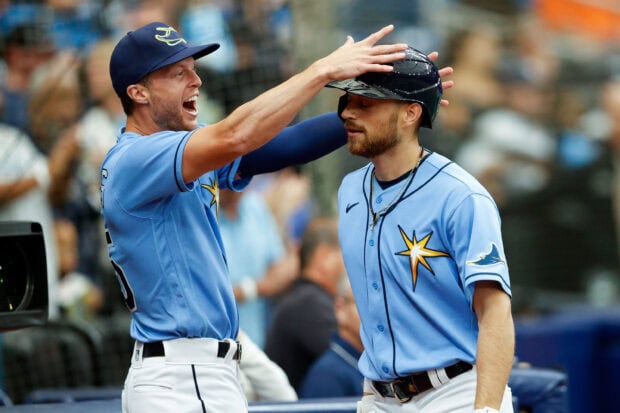 Two Tampa Bay Rays players celebrating during a baseball game wearing light blue uniforms