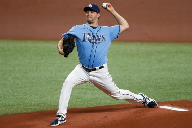 A Tampa Bay Rays player pitching during a baseball game on the field