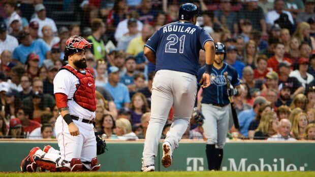 Tampa Bay Rays player Aguilar running during a baseball game with catcher and crowd in background