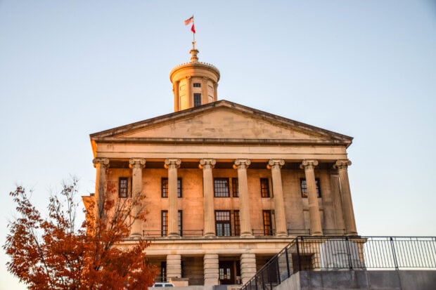 Historic Tennessee government building with autumn tree in front under clear sky