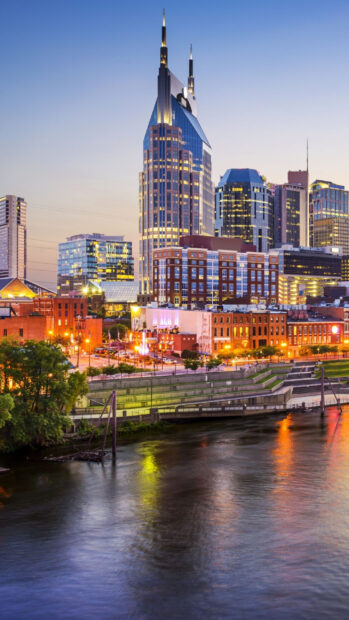 The Tennessee city skyline with iconic buildings reflecting on the river at dusk