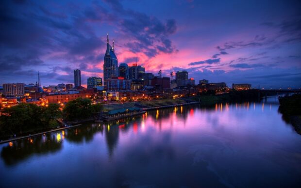 The Tennessee city skyline with colorful sunset reflections on the river at dusk