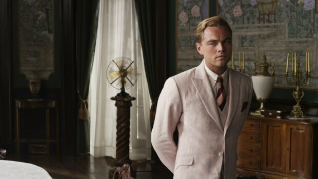 A man in a vintage suit stands in an elegant room in The Great Gatsby setting