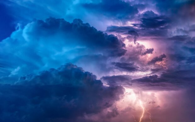 Dark clouds with lightning striking during a thunderstorm in the sky