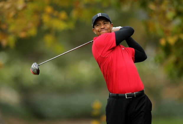 Tiger Woods playing golf during a tournament in a red shirt