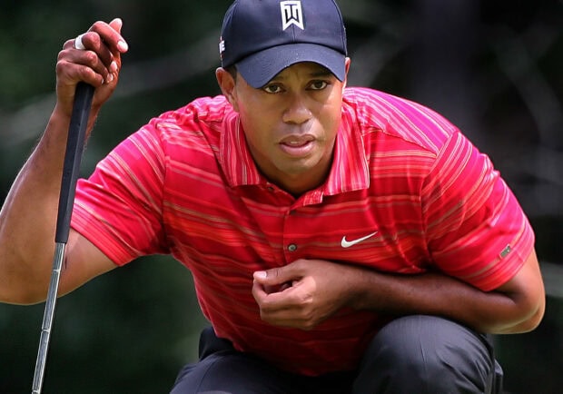 Tiger Woods concentrating on his golf putt during a tournament
