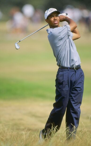 Young Tiger Woods swinging a golf club on the golf course