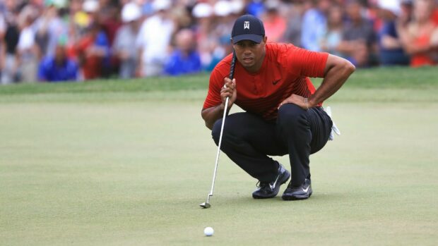 Tiger Woods lining up a putt on the golf green during a tournament