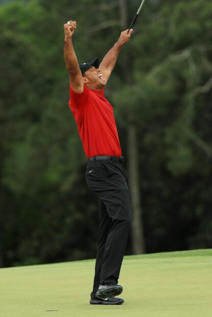 Tiger Woods celebrating a golf victory on a green golf course