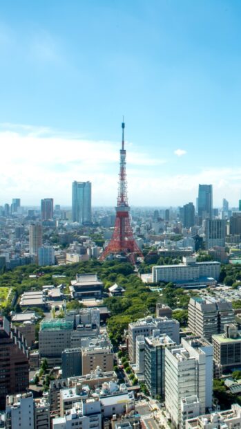 Tokyo Japan cityscape with the iconic red tower and surrounding greenery under a clear sky