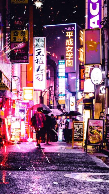 Tokyo Japan street scenes with people carrying umbrellas under bright neon signs