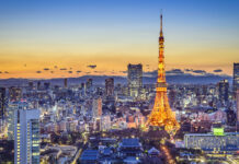 Tokyo Japan cityscape with illuminated tower at sunset sky background