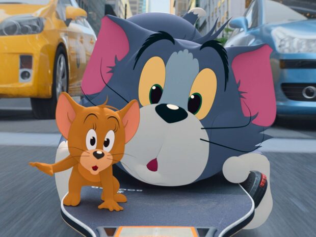 Tom and Jerry cartoon characters riding a skateboard on a city street in this Tom And Jerry wallpaper