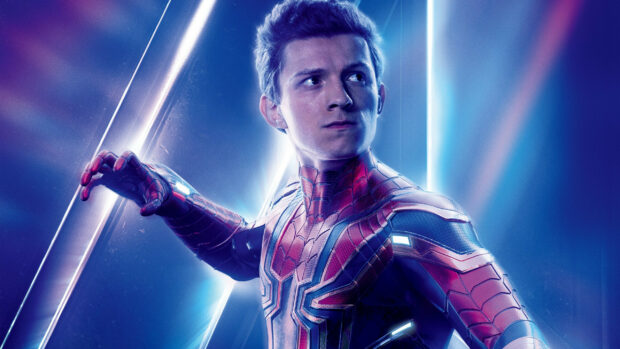 Tom Holland in his Spider Man suit looking back with glowing blue background lighting